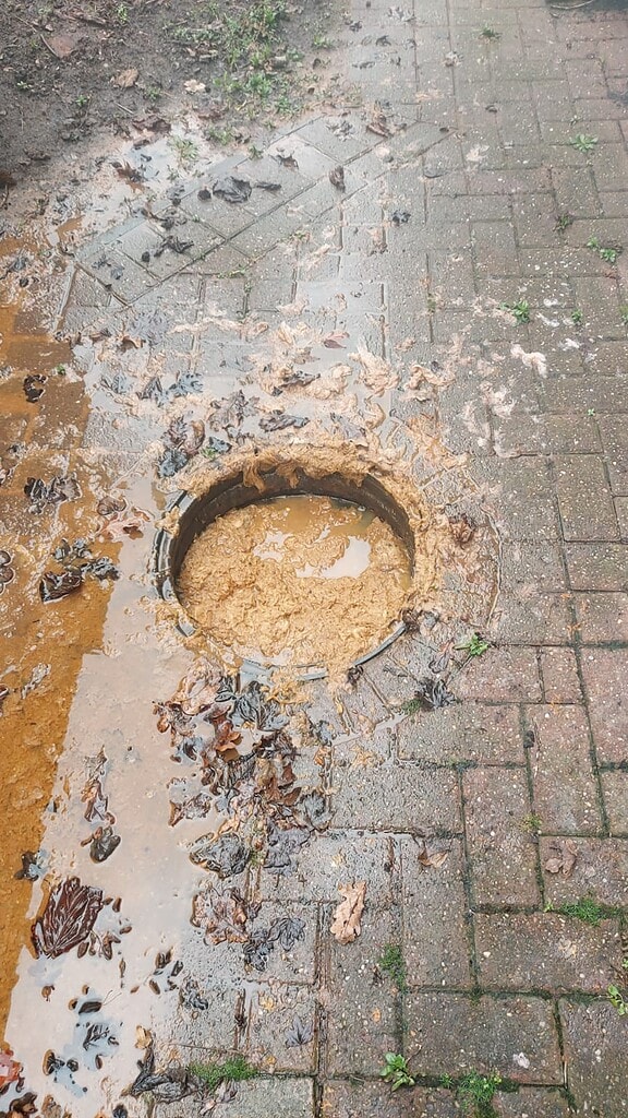 Blocked drain repair in Lichfield caused flooding on factory pavement.