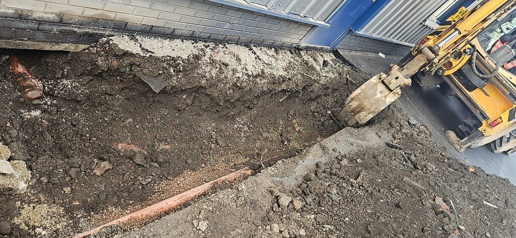 Excavation for commercial drainage repair in Derby with heavy machinery.