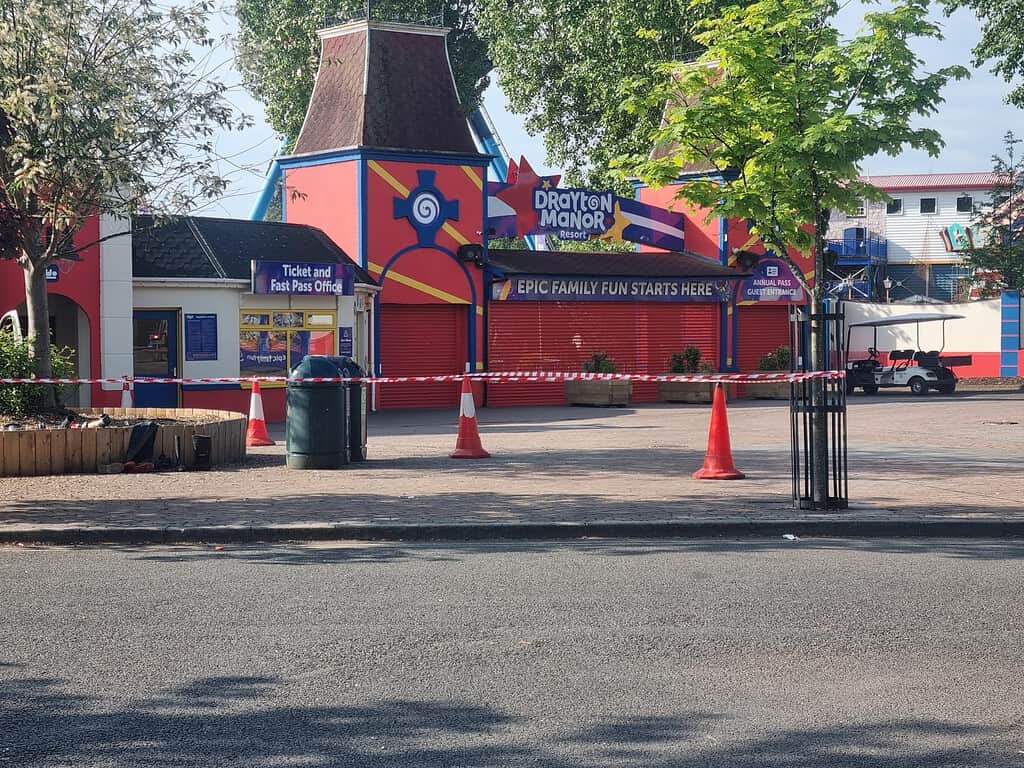 Drayton Manor amusement park entrance with colourful signage and safety barriers.