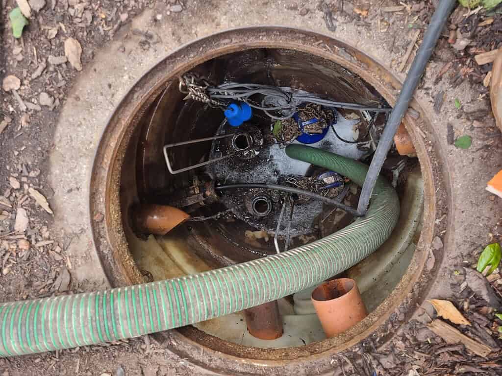 Drainage inspection chamber with equipment and water inside, used for sewer or drain maintenance.