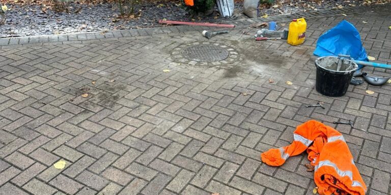 Re-laying a manhole cover during drainage repair work in an urban area.