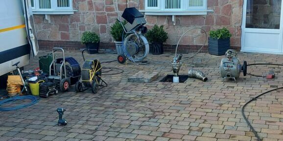 Installation of blue light lining and drain line system on residential patio.