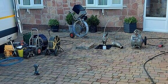 Installation of blue light lining and drain line system in residential outdoor area.