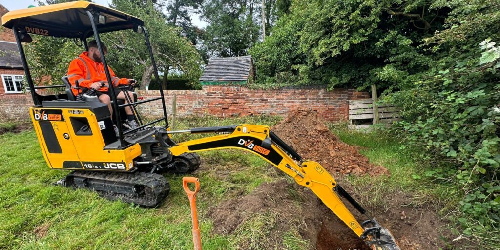 Excavator digging drainage trenches at a school site in Nottingham.